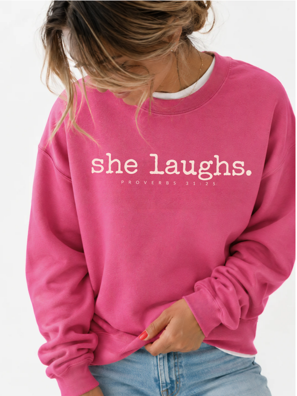 Woman wearing a hot pink She Laughs sweatshirt with ivory lettering