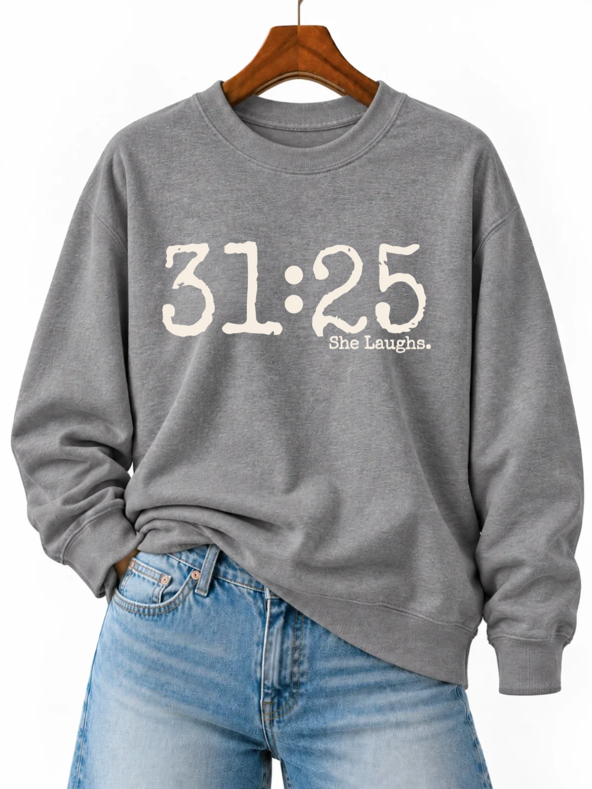 Gray 31:25 crewneck sweatshirt with large ivory lettering, styled on a wooden hanger with light-wash jeans.