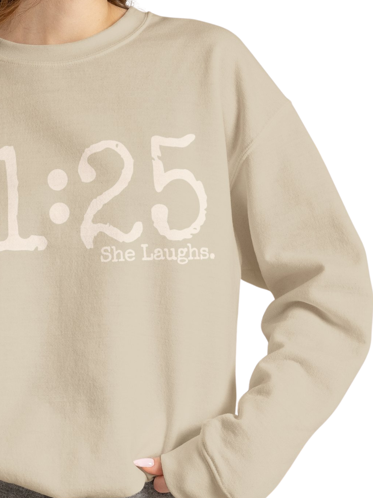 Close-up of oversized ivory 31:25 lettering and small She Laughs text printed on a Sand crewneck sweatshirt.