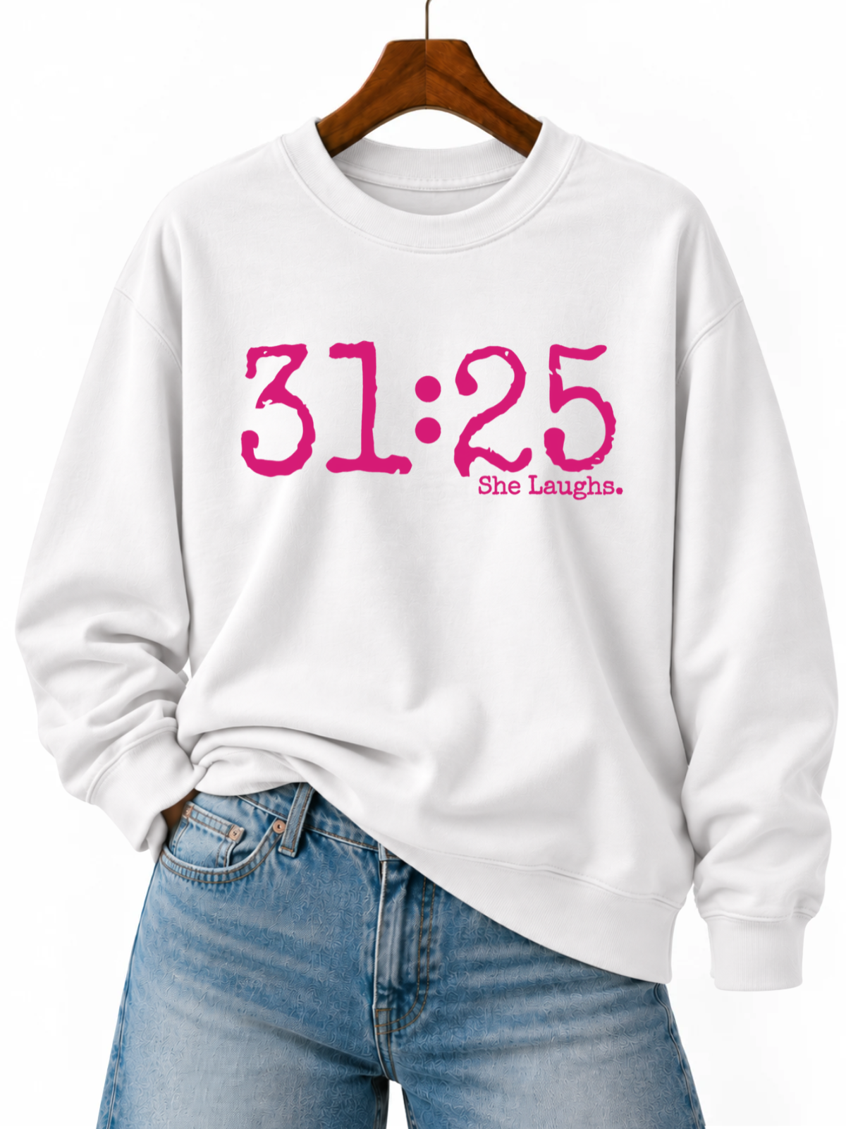 White 31:25 sweatshirt with oversized hot-pink front lettering, displayed on a wooden hanger with blue jeans.
