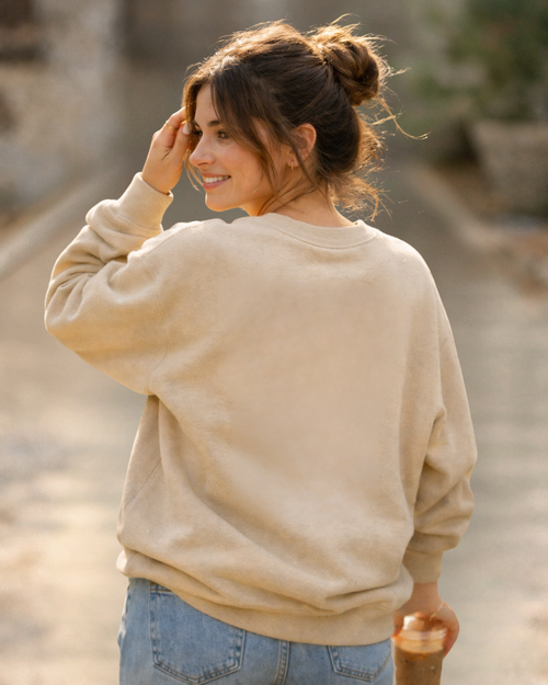 Woman wearing a beige alive in Christ 2 Cor. 5:17 sweatshirt and blue jeans outdoors