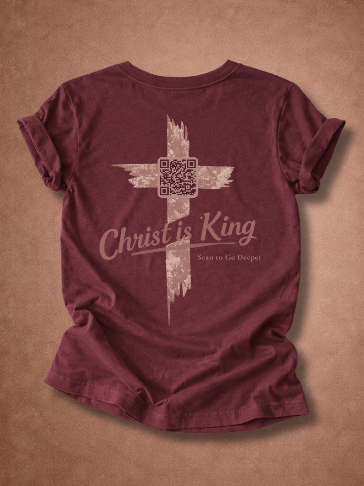 Maroon t-shirt with 'Christ is King' graphic on a brown background