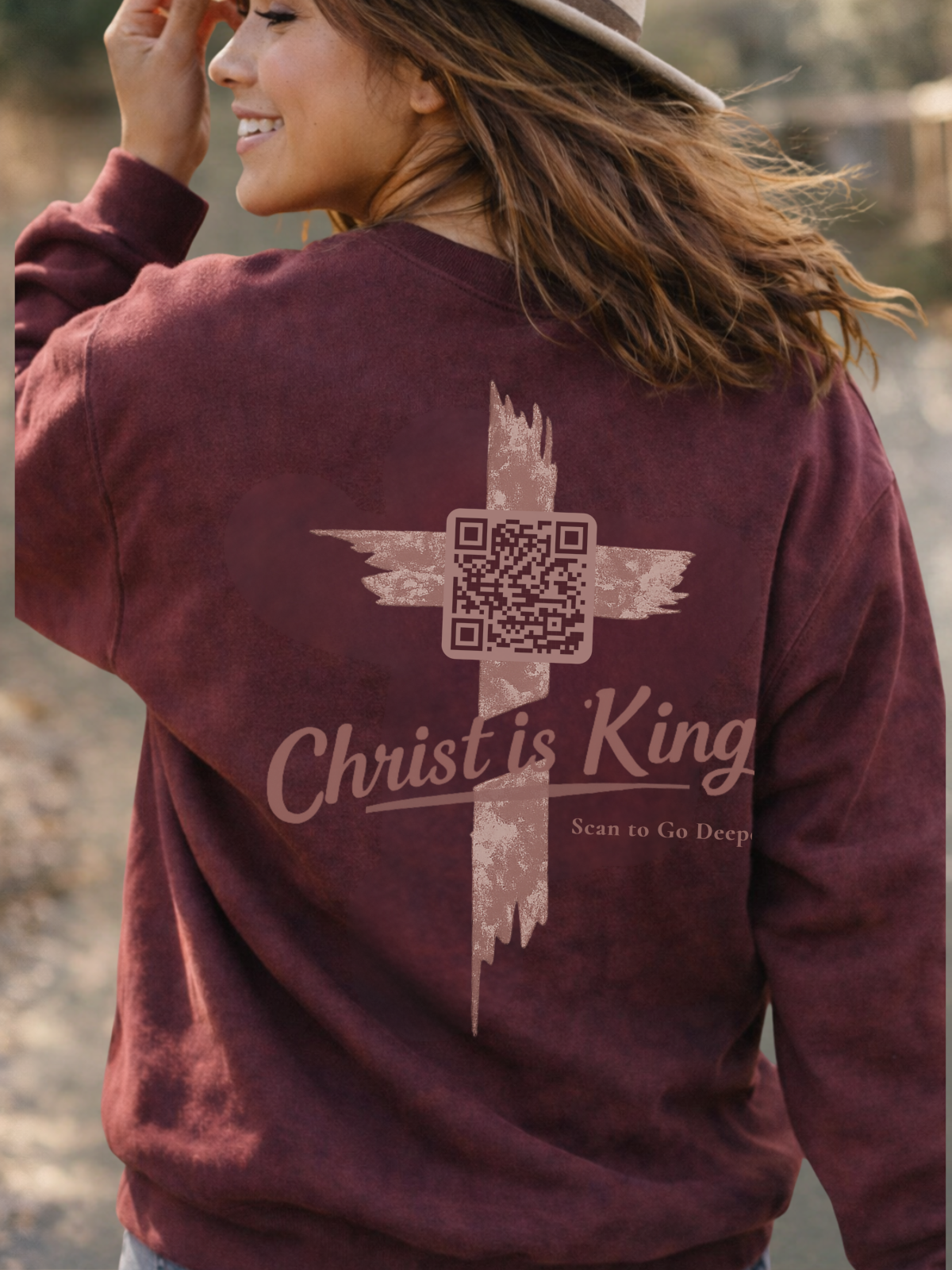 woman wearing a maroon sweatshirt with 'Christ is King' and a cross design on back John 12:12-15