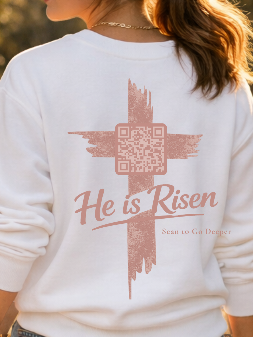 White sweatshirt with a cross and QR code design on the back, featuring the text 'He is Risen'. Matthew 28:6