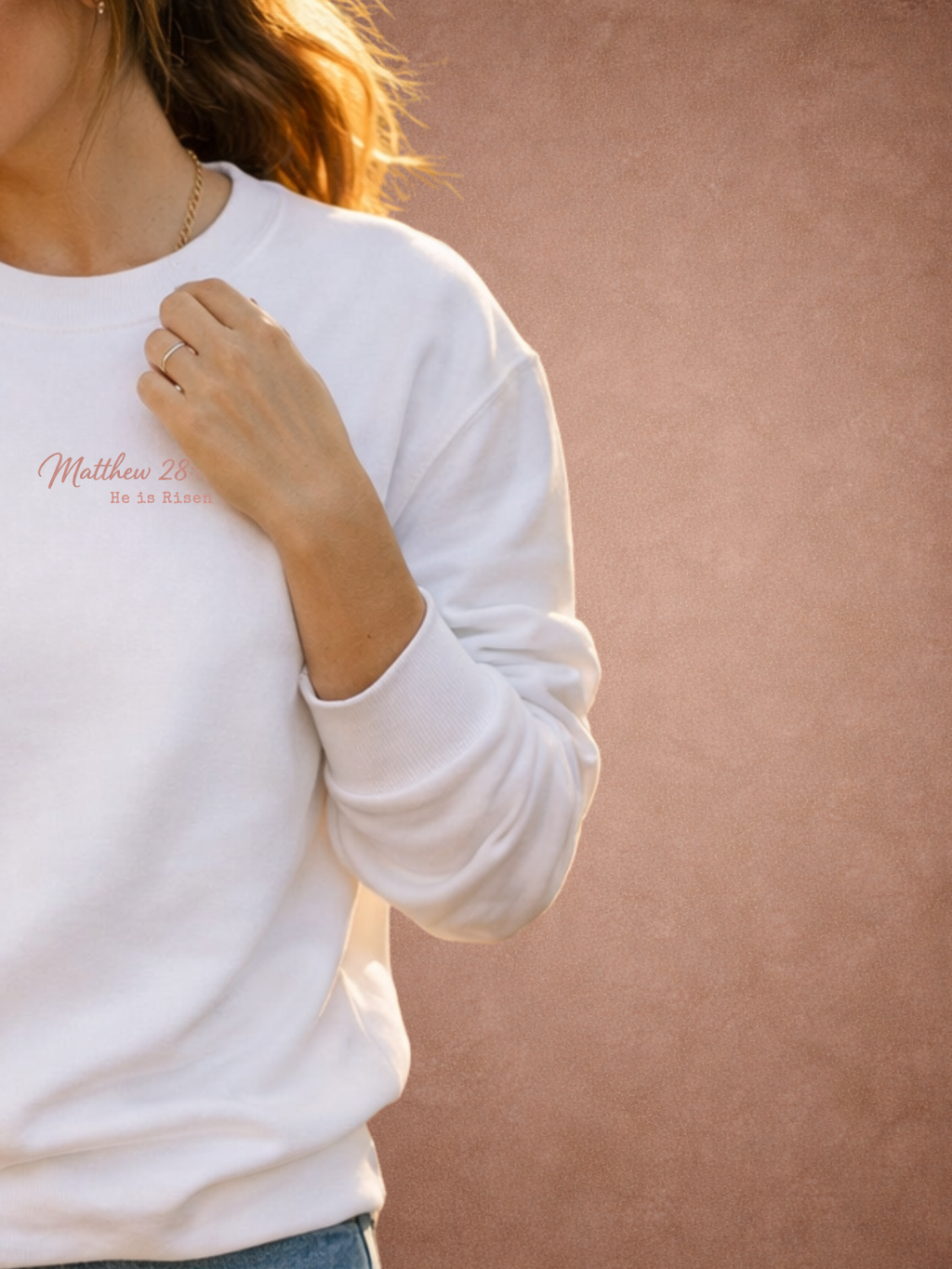 White sweatshirt worn by a person on a beige background